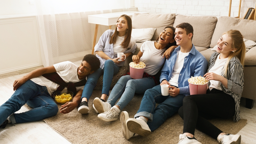 Tinejdžeri gledaju film, jedu kokice i druže se tokom rođendanske proslave u dnevnoj sobi