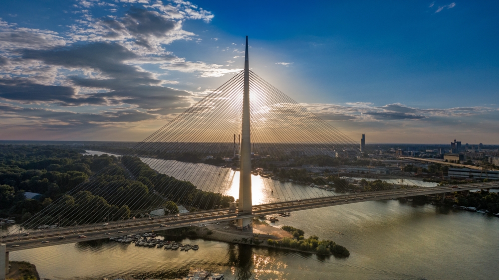 Pogled iz vazduha na Most na Adi i delove Beograda okružene rekom i zelenilom. Beograd nudi brojna naselja pogodna za život porodica sa decom.