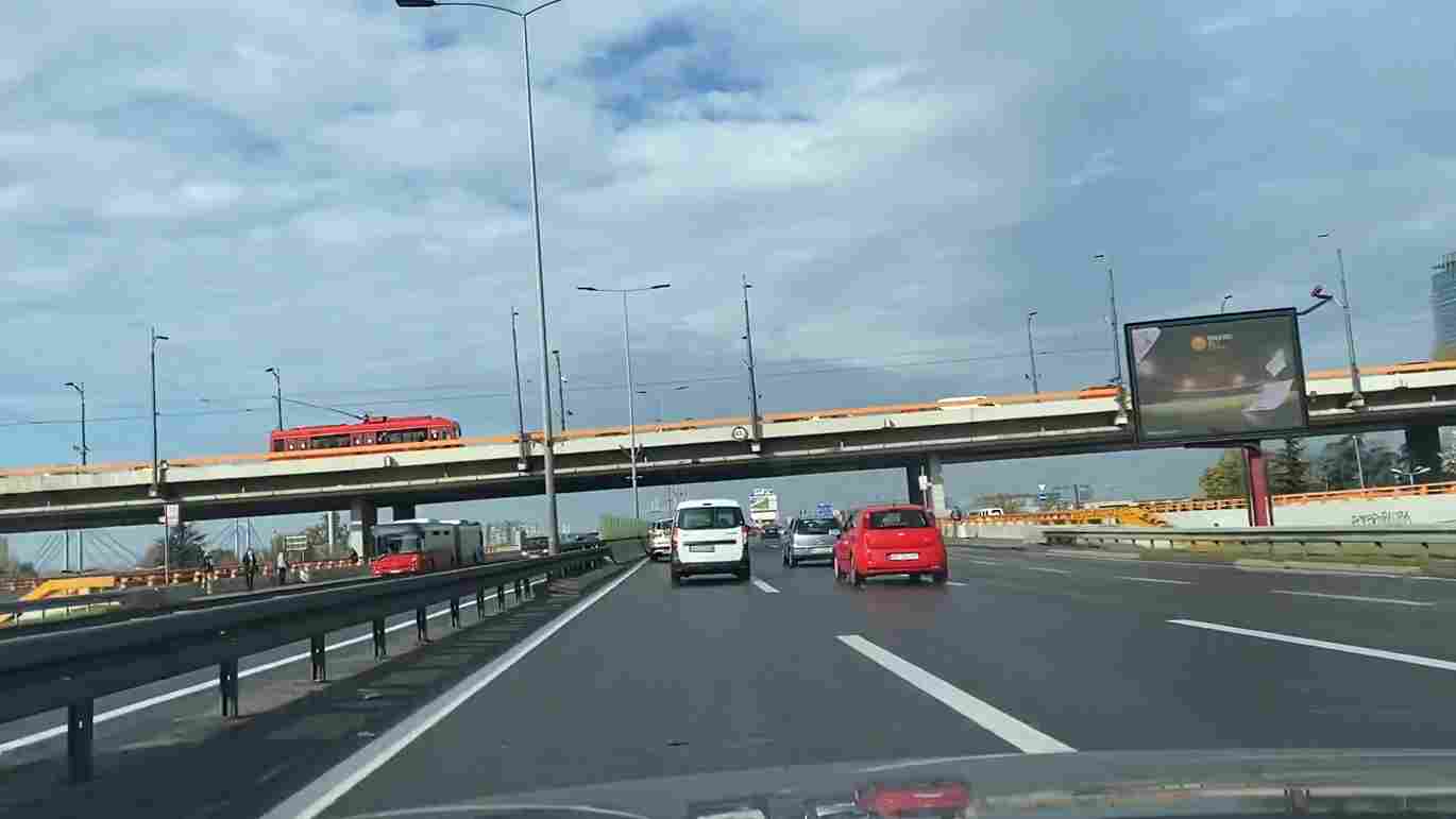 Vozila na autoputu kod mosta Gazela u Beogradu, sa bilbordom pored kolovoza.