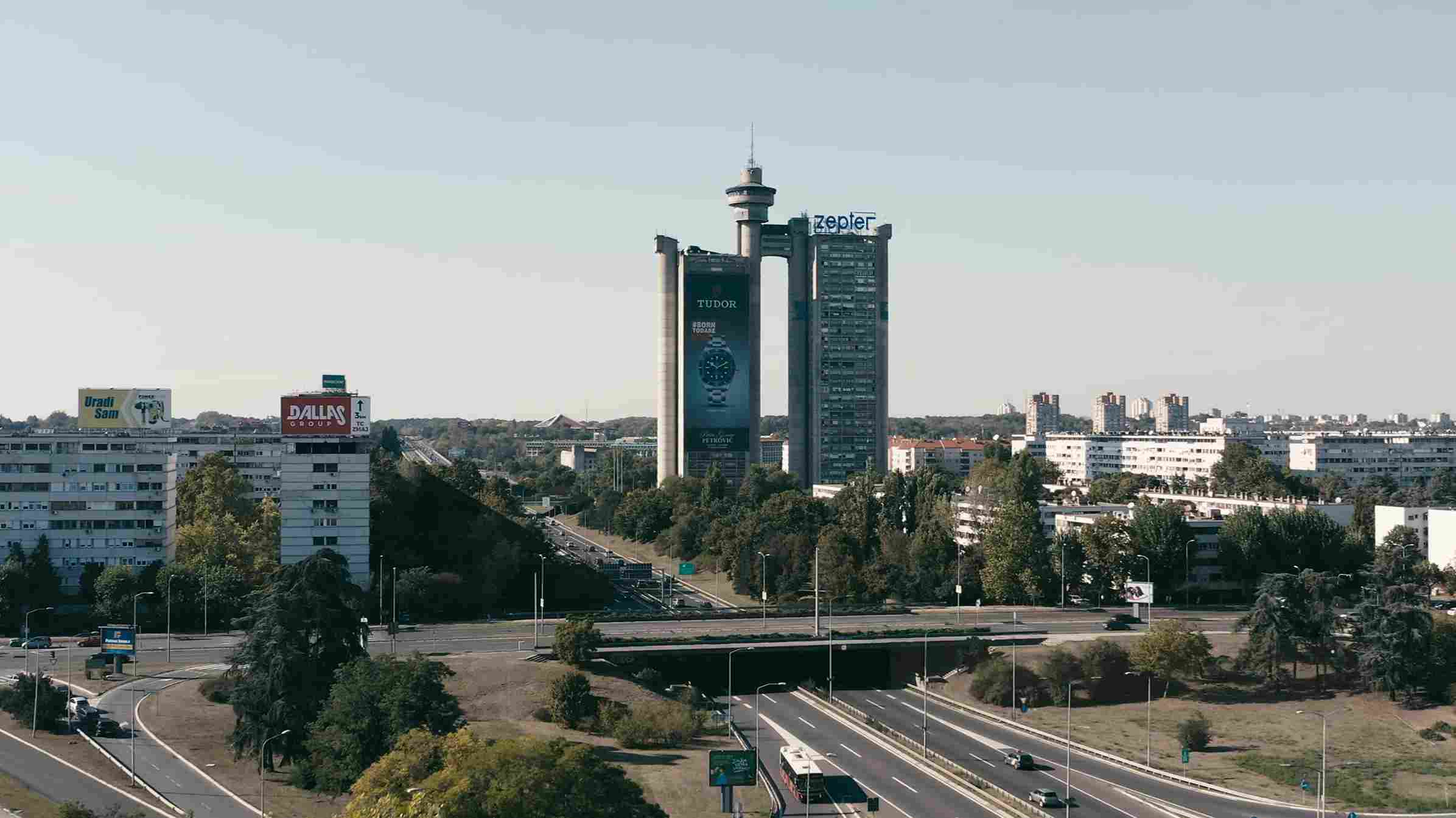 Panorama Novog Beograda sa širokim putevima, zgradama i visokim tornjem u pozadini.