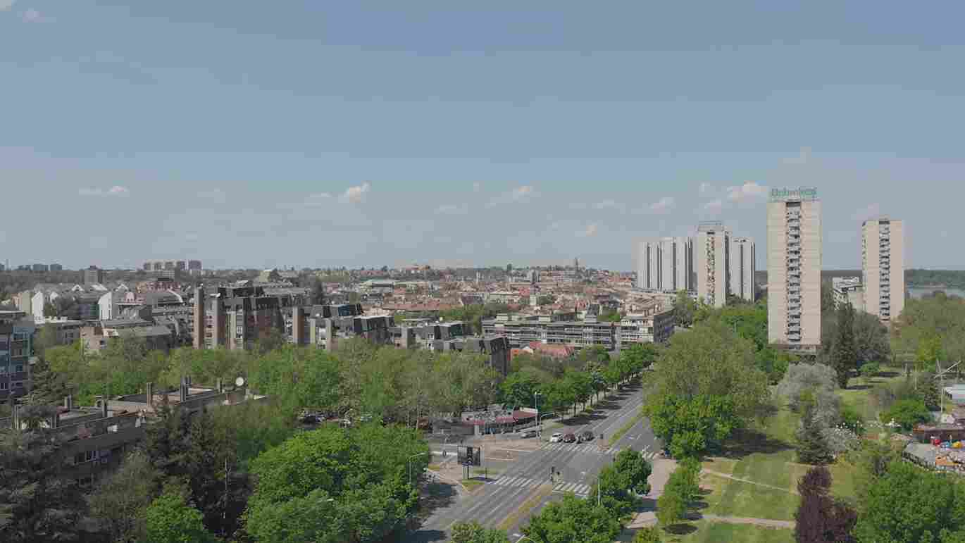 Panorama Zemuna sa prometnom raskrsnicom, drvoredima i visokim stambenim zgradama.