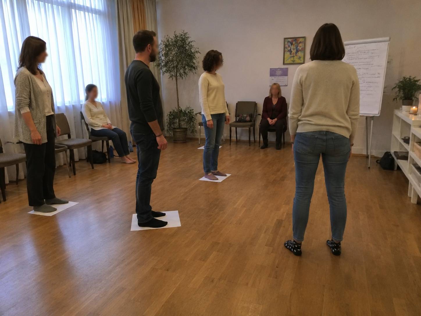 Učesnici stoje raspoređeni u prostoriji tokom radionice porodičnih konstelacija.